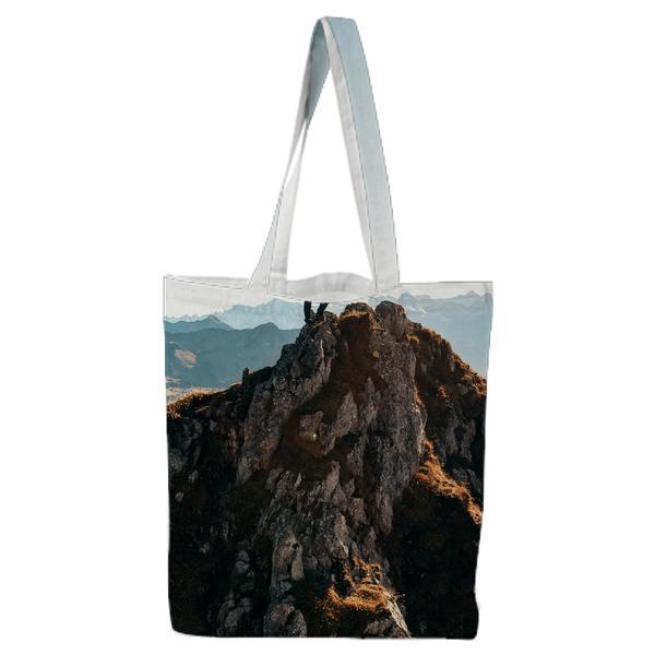 Man Standing On Brown Rocking Mountain Under Blue Sky And Yellow Sunlight Tote Bag