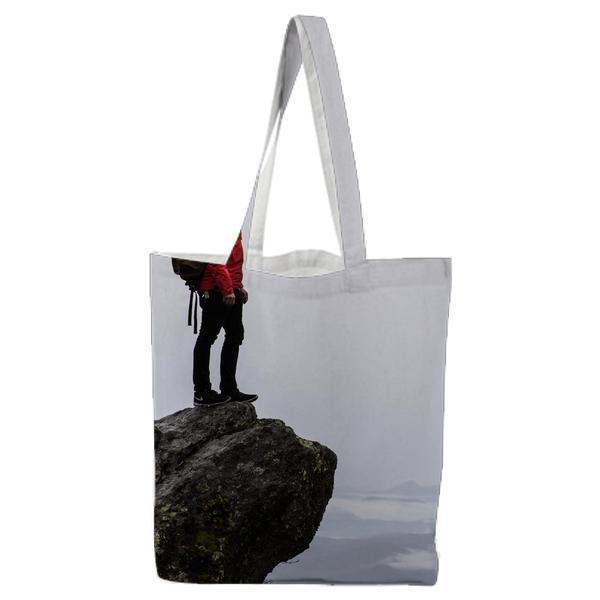 Man Standing On A Cliff Next To Sea Tote Bag