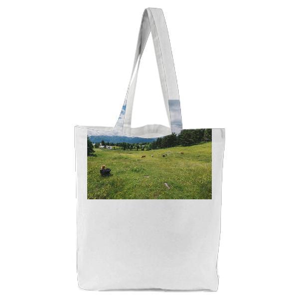 Person Sitting On Green Grasses Near Trees During Daytime Tote Bag