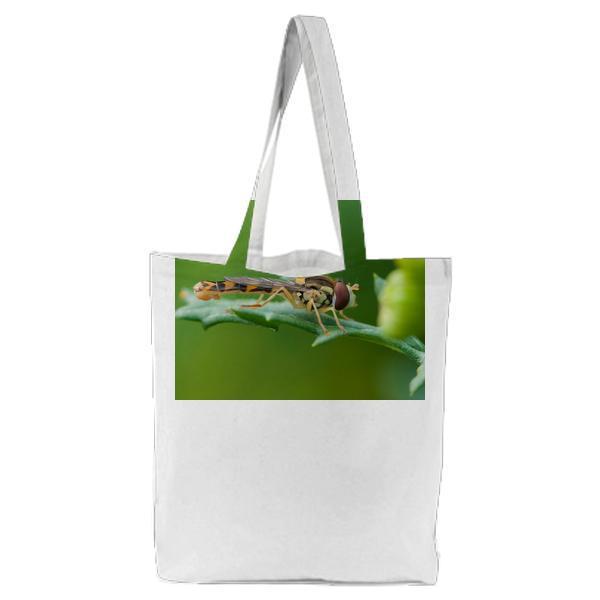 Brown And Yellow Robber Fly Perched On Green Leaf During Daytime Tote Bag