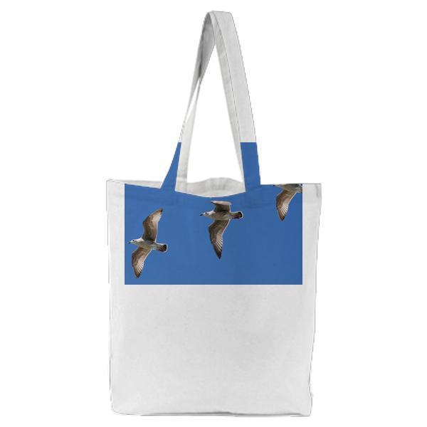 3 White Birds Flying Under Blue Sky Tote Bag