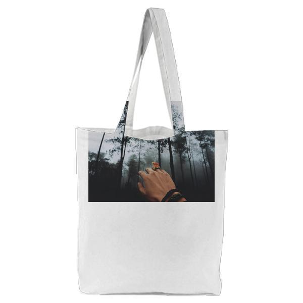 Person With Black Braided Bracelet Raising His Hand Facing Green Tall Trees Tote Bag