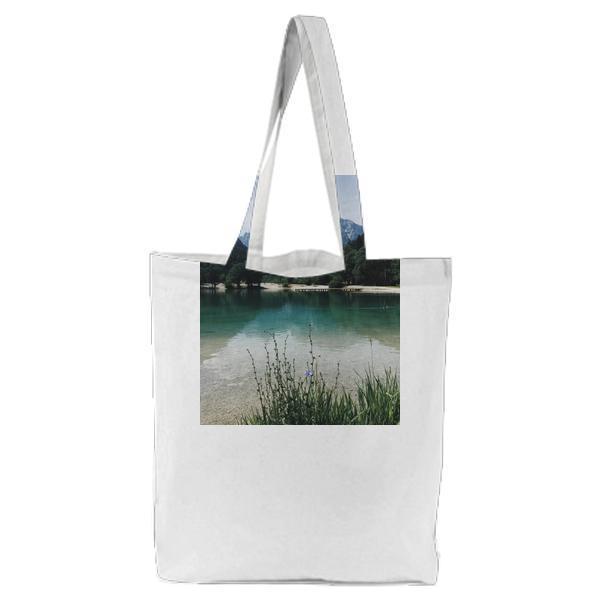 Body Of Water Near Green Leafed Trees Under Blue Sky During Daytime Tote Bag