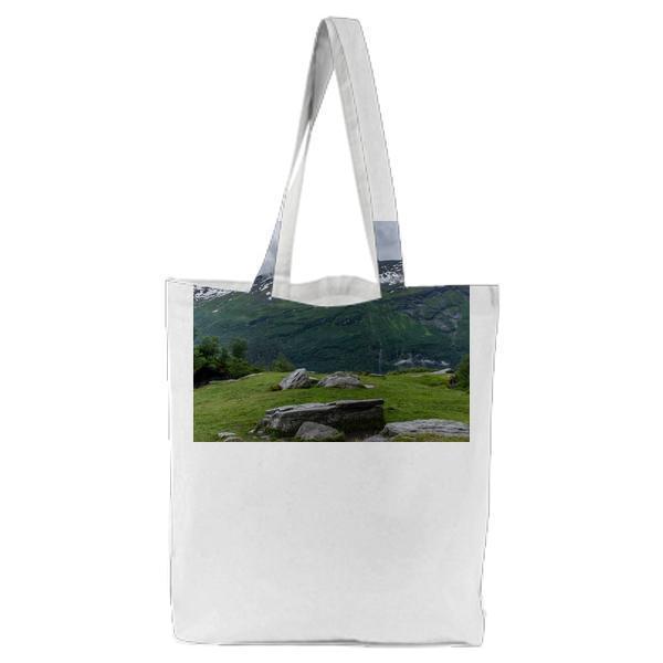 Green Grass Across Green And Brown Mountain During Daytime Tote Bag