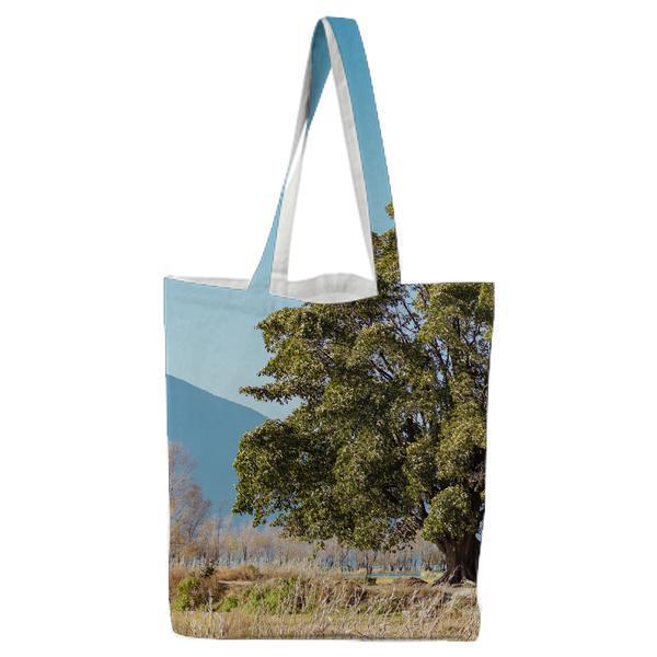 Green Leaf Trees In A Distant Of Mountain Under Clear Blue Sky Tote Bag