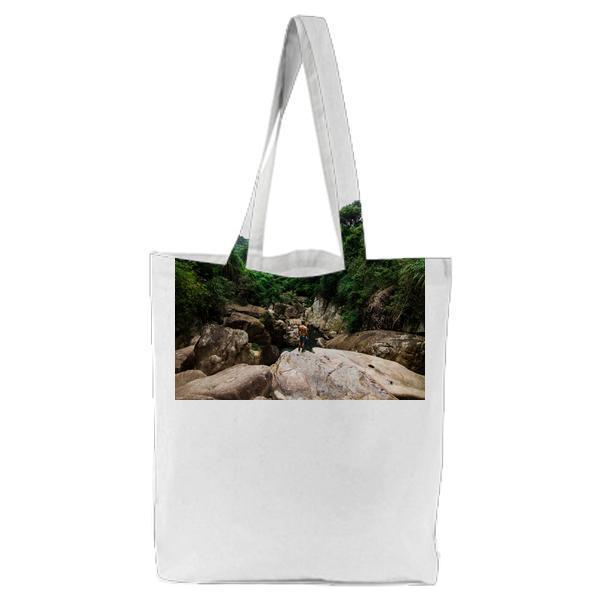 Man Standing On Grey Rock Surrounded By Trees During Daytime Tote Bag