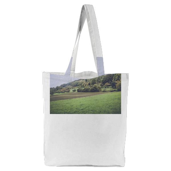 Green Grass Under Grey Clouds During Daytime Tote Bag
