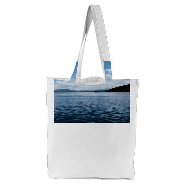 White Clouds And Blue Skies Over Lake Tote Bag