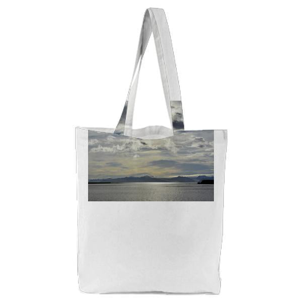 Brown Mountain Beside A Sea Under Grey Cloudy Sky Tote Bag