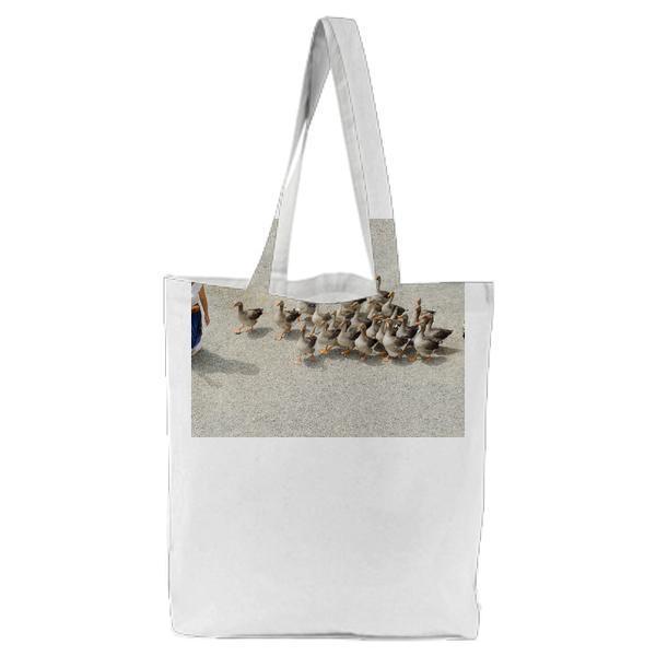 Woman In White Sleeveless Shirt Walking On Gray Sand Followed By Brown And Black Ducks Dog Tote Bag