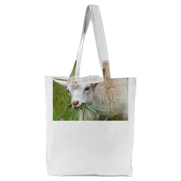 White Goat Eating Grass During Daytime Tote Bag