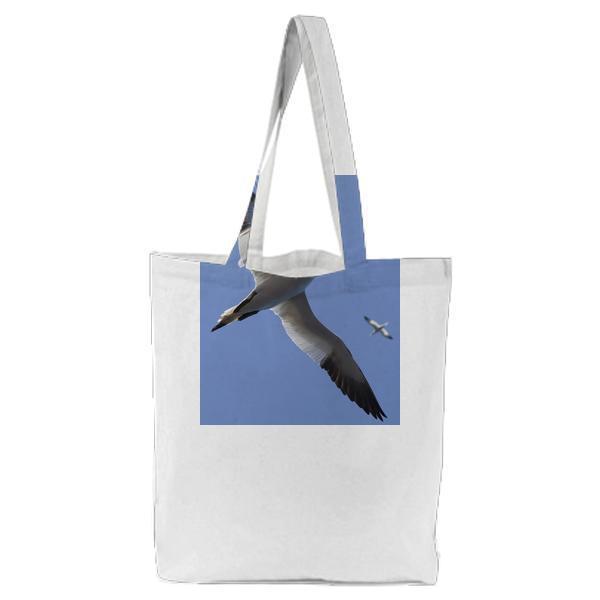 White And Black Bird Flying Under Blue Sky During Daytime Tote Bag