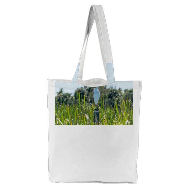 White And Yellow Bird On Pole Beside Grasses During Daytime Tote Bag